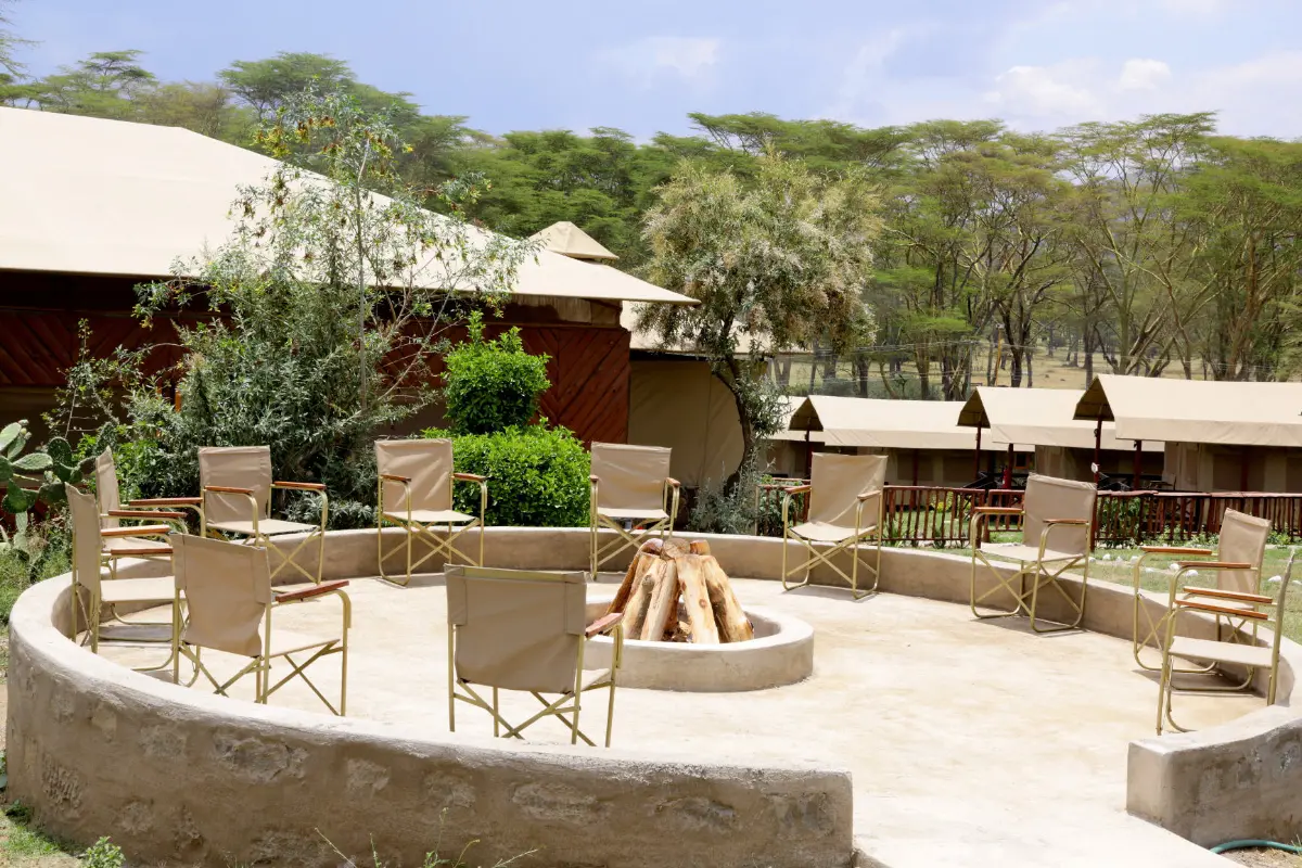 Stone fire pit surrounded by chairs on a terrace at a campsite in Naivasha